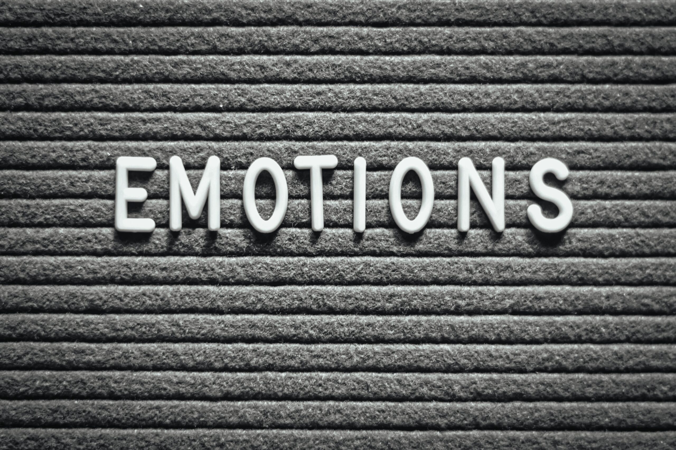 Letter board with the word 'Emotions' on a gray lined background.